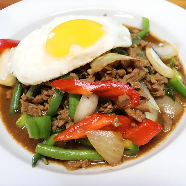 B & K Asian Kitchen's stir-fried beef with colorful bell peppers, onions, and a fried egg.